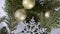 A bunch of golden shiny and matte Christmas balls and silver snowflakes lie on a green juniper branch and spin slowly clockwise.