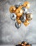 Bunch of golden and silver gray metallic balloons and confetti on glistering background. Birthday, holiday or party background.