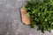 A bunch of green fresh parsley on a rectangular cutting wooden board on a dark background