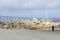 Bunch of large concrete tetrapod breakwaters lie on the seashore near pier