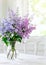 Bunch lilac flowers in vase on table