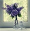 Bunch of lilacs on a window sill and origami figure of a raven