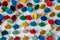 Bunch of many colorful thumbtacks as multi-color office supply metal pushpins circles in yellow, green, blue, red and white desk