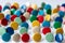 Bunch of many colorful thumbtacks as multi-color office supply metal pushpins circles in yellow, green, blue, red and white desk