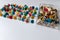 Bunch of many colorful thumbtacks as multi-color office supply metal pushpins circles in yellow, green, blue, red and white desk