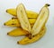 Bunch of mature yellow bananas together with one cutted in the middle.