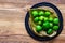 bunch of mini kiwis on a golden metal leaf plate flat lay on a wooden background isolated