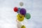 Bunch of multi-colored balloons soar up to the cloudy sky