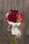 Bunch of multicolor rose flowers wrapped in newspaper over wooden background.