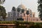 Bunch of palm trees and mesmerizing view of humayun tomb memorial from the side of the lawn at winter foggy morning