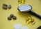 Bunch of pills and capsules, box for storage of drugs and medical stethoscope and blood pressure meter on yellow background, healt