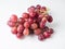 A bunch of pink large grapes on a white background