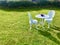 A bunch of purple lavender on white round table and chairs under the sunshine.