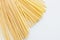 Bunch of raw linguine pasta spread on white background,