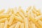 Bunch of raw macherroni pasta in the lower part of white background