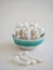 bunch of raw mushrooms in a rustic green and white ceramic bowl