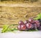 Bunch of red grapes and leaves and wooden pattern