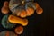 Bunch of red and green pumpkins on dark wood