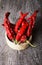 Bunch of red hot peppers lying in a wicker basket on old wooden