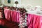 The bunch of red roses, pionies and ranunculus as a part of wedding table decoration