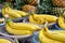 Bunch of ripe Bananas and pinneaples at background in a street market in Bangkok, Thailand. Horizontal