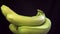 A bunch of ripe bananas with water drops on a black background