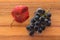 Bunch of ripe Cabernet Sauvignon grapes with red leaf on wooden chopping board