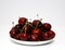 A bunch of ripe cherries with peduncles lies on a white background. Large collection of fresh red cherries. Ripe cherries