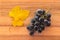 Bunch of ripe Merlot grapes with yellow leaf on wooden chopping board