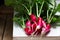 A bunch of ripe radishes with tops on a wooden background