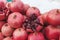 A bunch of ripe red pomegranates on the street in winter. One of the fruits is cut in half. Visible grains and bones