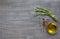 Bunch of rosemary, condiment and olive oil on the wooden backgro