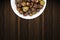 A bunch of round red chillies in white bowl in a nice wooden background