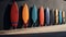 A bunch of surfboards are lined up against a wall