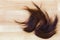 Bunch of trimmed cut off reddish brown hair on wooden floor with