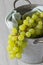 Bunch of white seedless grapes on a green tea towel  in a metal bucket container.