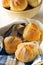 Bunch of whole, fresh baked wheat buns in baking basket and on k