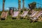 Bunch of wooden foldable beach chairs on a grassy ground