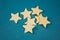 A bunch of wooden stars on a blue background chaotically scattered