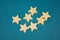 A bunch of wooden stars on a blue background chaotically scattered
