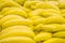 Bunch of yellow bananas in supermarket. Fresh and healthy. Shallow depth of field, focus on the front banana