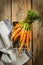 Bunch of young or baby carrots on wooden rural kitchen table