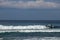 A bunch of young surfers surf at a popular location at Nyang Nyang Beach in Bali, Indonesia. Large waves break and form a thick