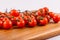 bunches of cherry tomatoes on top of a wooden cutting board