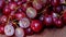 Bunches of fresh ripe red grapes on a wooden textural surface.