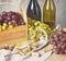 Bunches of grapes, wineglass, bottles and corks on wooden background.