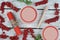 Bunches of red currant berries on a light table and spoon of spindle with beeswax candle, top view