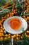 Bunches of ripe, orange sea-buckthorn on branches with sea-buckthorn oil