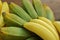 Bunches of tasty bananas on wooden table, closeup