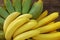 Bunches of tasty bananas on wooden table, closeup